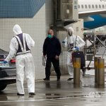 Tajvanski aktivist izpuščen iz kitajskega zapora Prodemokratični aktivist Lee Ming-che (na sredini) je ob prihodu na Tajvan pospremljen v karanteno. Foto: CNA