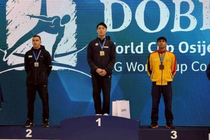 Tajvanski telovadec Tang Chia-hung (v sredini) pozira z zlato medaljo na stopničkah ob srebrnem in bronastem medalistu v nedeljo na Hrvaškem. Foto: Huang Bo-rui